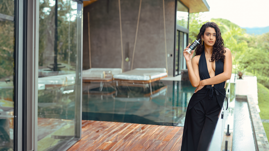 Curly hair model in Puerto Rico holding VCurls Humidity Resistant Glaze during summer. Her coily curls are styled using the product, appearing defined, frizz-free, and summer-ready.